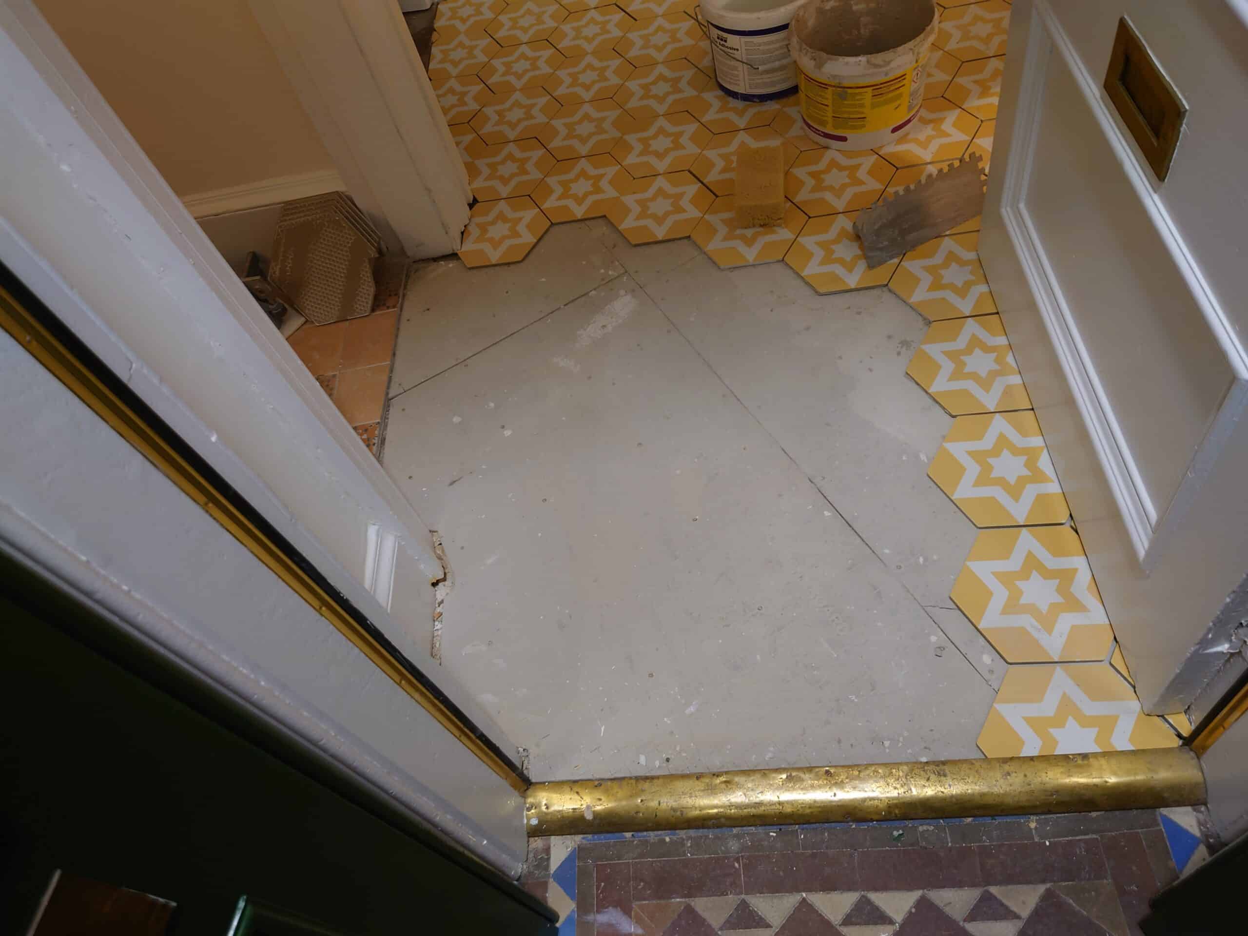New yellow patterned tiles being installed in a hallway at Woodlands.