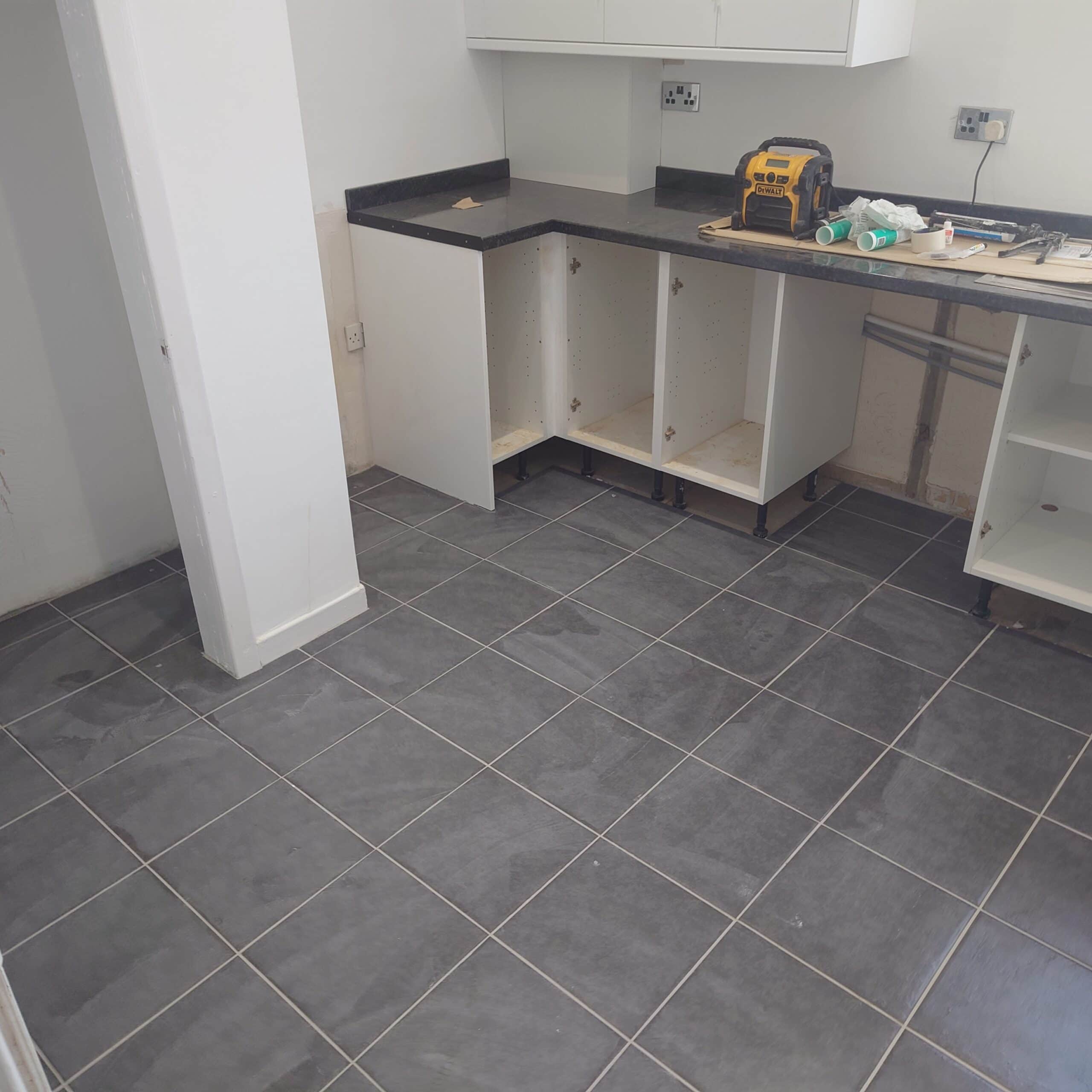 Modern slate floor in kitchen under renovation, showcasing durable tiling.